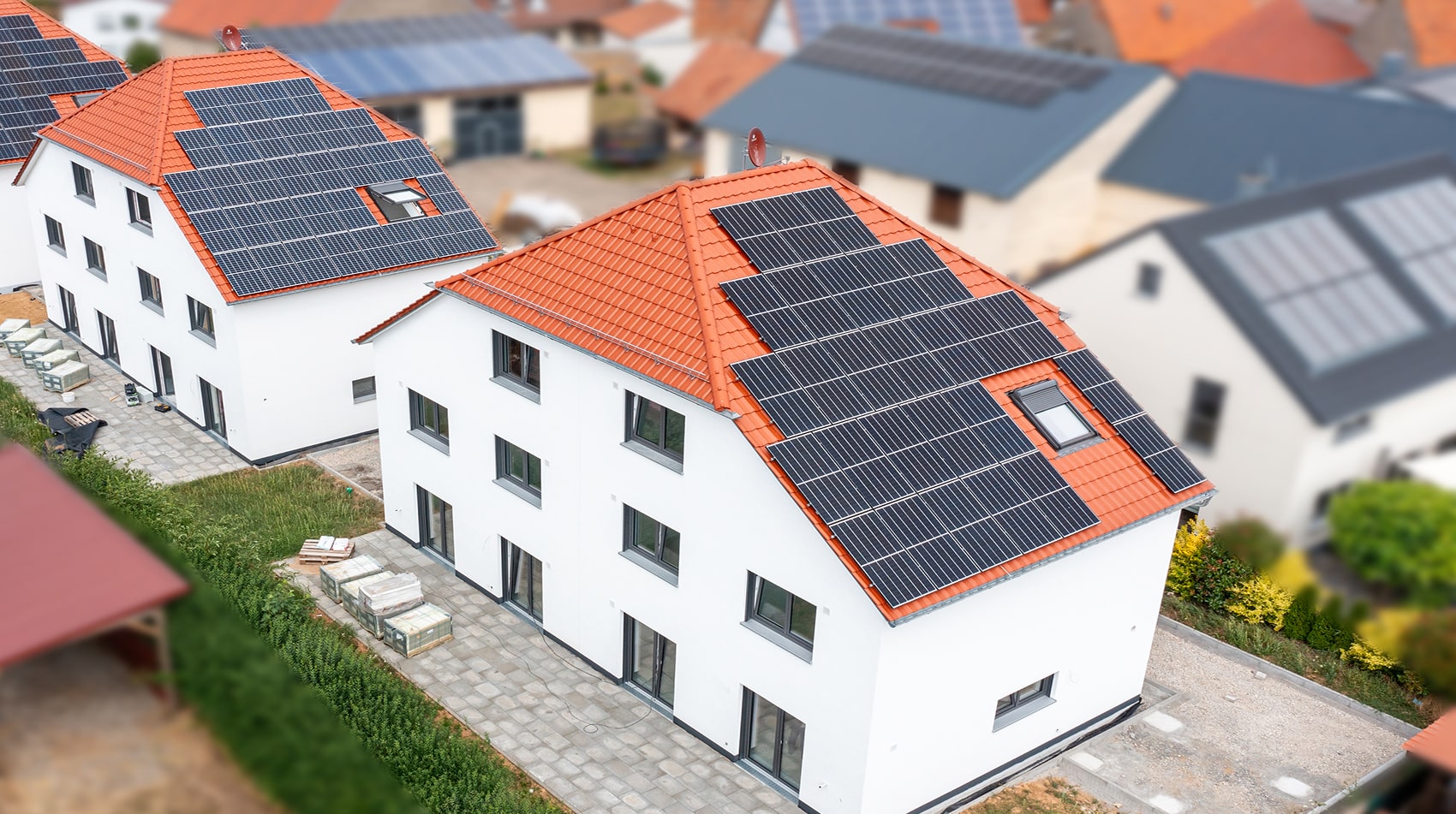 Luftaufnahme von neu gebauten Mehrfamilienhäusern mit Photovoltaikanlage, betreut von der Hoch2 Hausverwaltung im Raum Würzburg